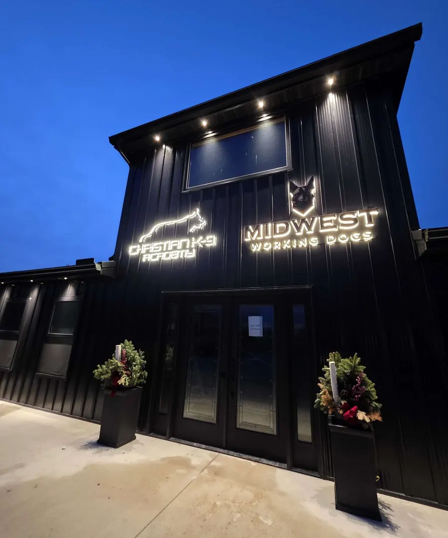 The Christian K-9 Academy facility building lit up at dusk